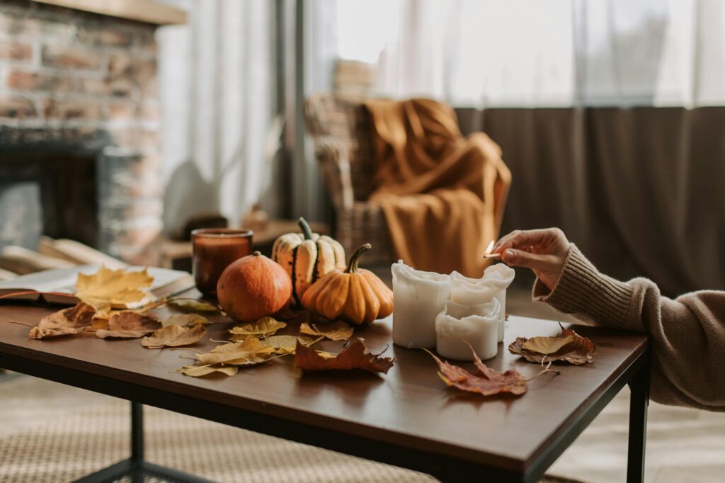 Herbstlicher Tisch mit Blättern, Kürbis und Kerzen